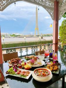 a table with plates of food and a view of the eiffel tower at Hiranyakul House in Bangkok