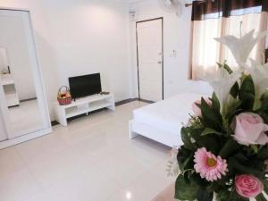 a white living room with a bed and a tv at Pichayapa Place in Ban Pa Sang (1)