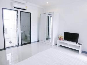 a white room with a television and a bathroom at Pichayapa Place in Ban Pa Sang (1)
