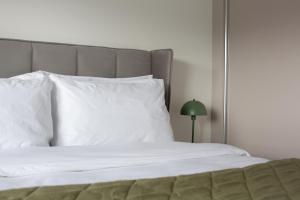 un letto con cuscini bianchi e una lampada verde di Penthouse Apartment at Loch Lomond with 2 bedrooms a Balloch