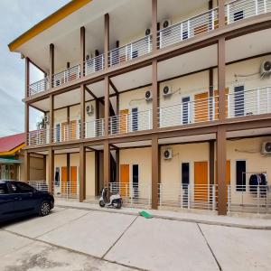 un bâtiment avec un scooter garé devant lui dans l'établissement FARAH Homestay Syariah Mitra RedDoorz, à Pekanbaru 12 autres photos