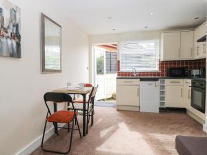 a kitchen and dining room with a table and chairs at Mutley Hall in Chichester
