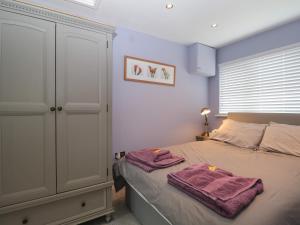 a bedroom with a bed with purple towels on it at Mutley Hall in Chichester