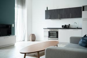 a living room with a table and a kitchen at Prime Park Deluxe Apartment Aschaffenburg in Aschaffenburg