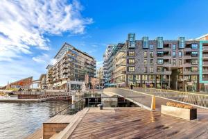 a bridge over a river next to some buildings at Tjuvholmen - balcony with seaview & 2 bedrooms in Oslo