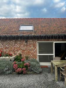 a brick house with a table and a window at Melkhuisje in Dendermonde