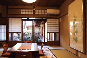 a room with a table and chairs and a window at Show-an Machiya Inn in Kyoto