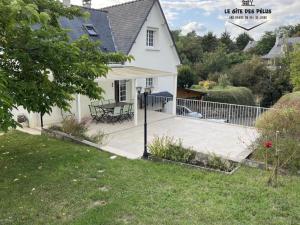 a white house with a fence and a patio at Le gîte des pélus in Rochecorbon
