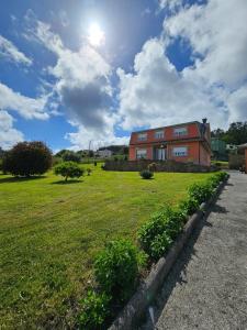 a house in a field with the sun in the sky at Vicia in O Vicedo