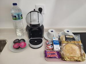 a counter with a coffee maker and a bottle of water at Moderno y lujoso Apartamento CASTELAR 2 in Alcazar de San Juan