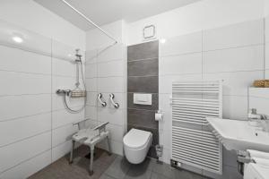 a white bathroom with a toilet and a sink at Barrierefrei - Privatparkplatz - zentral im Grünen in Magdeburg +14 photos