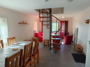 a dining room with a table and a spiral staircase at Chalet paisible à 4km de la station des Carroz - Chalet St François de Sales in Arâches-la-Frasse