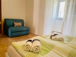 a bedroom with a bed with towels and a chair at Boutique Apartment with Private Pool for Your Exclusive Use in Novigrad Istria +20 photos