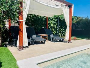 a pavilion with chairs and a table next to a pool at Boutique Apartment with Private Heated Pool in Novigrad Istria
