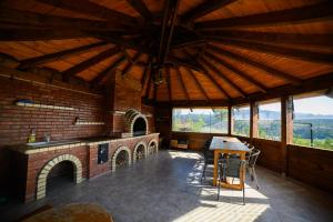 a large room with a brick fireplace and a table at Chalet First Hill in Gura Humorului