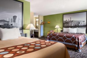 a hotel room with two beds and green walls at Super 8 by Wyndham Dyersville in Dyersville