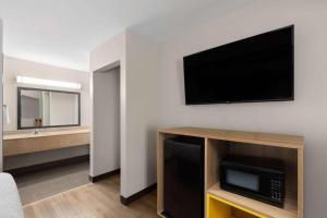 a living room with a flat screen tv on a wall at Days Inn by Wyndham Clarksville North EXIT 4 in Clarksville