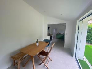 アレにあるMaison rénovée au charme typique du Bassin d'Arcachonの木製のテーブルと椅子のあるダイニングルーム