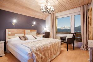 ein Schlafzimmer mit einem großen Bett und einem großen Fenster in der Unterkunft Hotel du Lac in Crans-Montana