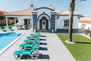 eine Reihe von Liegestühlen neben einem Swimmingpool in der Unterkunft Villa Jorge by Ecovillas Albufeira in Galé