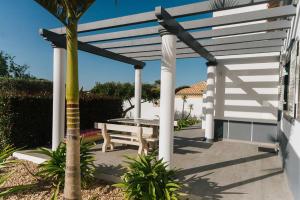 eine weiße Pergola mit einem Picknicktisch auf der Terrasse in der Unterkunft Villa Jorge by Ecovillas Albufeira in Galé
