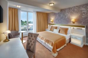a hotel room with a large bed and a table at Hotel Savoy Prague in Prague
