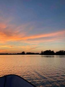 a boat on a body of water at sunset at Cabana lac Apa Stefania in Medieşu Aurit
