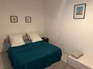 a bedroom with a bed with a blue blanket at Le nid douillet in Marmande