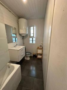 a bathroom with a tub and a sink and a toilet at Le nid douillet in Marmande