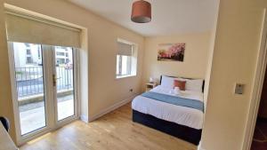 a bedroom with a bed and a large window at Five Bedroom Apartment Athlone in Athlone