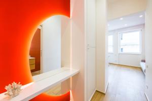 a room with an orange wall and a mirror at NUOVO appartamento nel cuore di Napoli AT TWENTY ONE - CORAL in Naples +25 photos