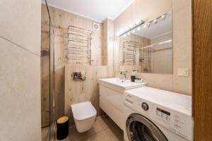 a bathroom with a sink and a washing machine at TUT Staroevreyska С Apartment in Lviv
