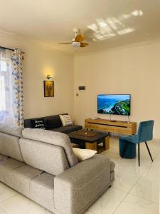 a living room with a couch and a flat screen tv at 3-Bedroom Apt with Oceanviews, 1min Walk to Beach - NYHA2 in Flic-en-Flac +25 photos