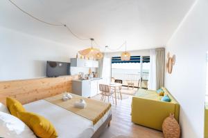 a room with a bed and a kitchen and a living room at Hôtel Café Miramar in Le Grau-du-Roi