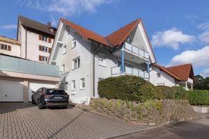 een auto geparkeerd voor een wit gebouw bij Ferienwohnung Herzlicht in Titisee-Neustadt