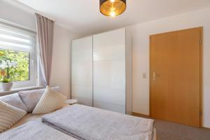 een slaapkamer met een bed en een groot raam bij Ferienwohnung Herzlicht in Titisee-Neustadt