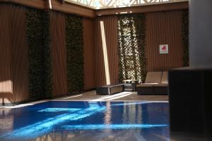 a swimming pool in a room with plants on the walls at Wow Diamond Hotel in Jeddah