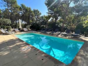 ein Swimmingpool mit Liegestühlen und ein Swimmingpool in der Unterkunft Calme absolu Luberon et piscine partagée in Lauris