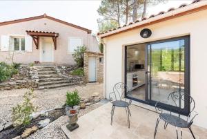 eine Terrasse mit zwei Stühlen vor einem Haus in der Unterkunft Calme absolu Luberon et piscine partagée in Lauris
