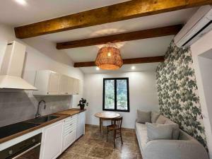eine Küche mit einer Couch und einem Tisch in einem Zimmer in der Unterkunft Calme absolu Luberon et piscine partagée in Lauris