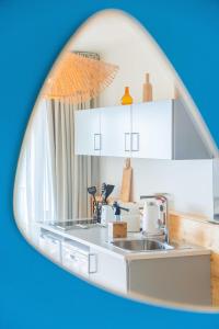 a kitchen with white cabinets and a sink at Hôtel Café Miramar in Le Grau-du-Roi
