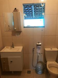 un bagno con un water, un lavandino e una finestra di Sítio Recanto do Pardal a Santa Rita de Caldas