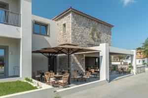 a restaurant with tables and chairs under an umbrella at Villa Sophia in Kalliópi