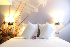 - un lit avec des oreillers blancs et 2 lampes dans l'établissement Mercure Paris Malakoff Parc des Expositions, à Malakoff