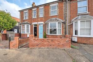 una casa in mattoni rossi con una porta blu di Delightful 10 St Martins - 2 bed, 2 bathroom with parking available a Bury Saint Edmunds