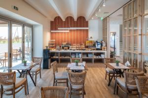 a restaurant with tables and chairs and a kitchen at Villa Sophia in Kalliópi