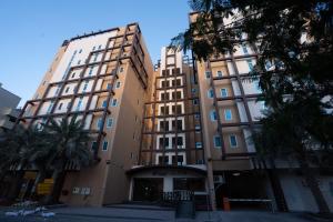 Un edificio alto con palmeras delante. en Al Liwan Residence, en Doha