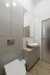 a bathroom with a sink and a toilet and a mirror at Luxury Retreat Centrum Wiszące ogrody FreeParking in Łódź