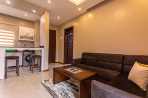 a living room with a couch and a table at Natra Apartments Entebbe in Entebbe