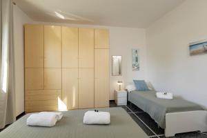 a bedroom with a bed and two white towels at "Lomellina Bay" 10 minuti a piedi dal mare in Varazze